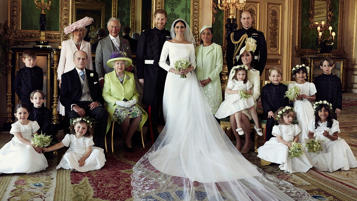 In this photo released by Kensington Palace on Monday May 21, 2018, shows an official wedding photo of Britain's Prince Harry and Meghan Markle, center, in Windsor Castle, Windsor, England, Saturday May 19, 2018. Others in photo from left, back row, Jasper Dyer, Camilla, Duchess of Cornwall, Prince Charles, Doria Ragland, Prince William; center row, Brian Mulroney, Prince Philip, Queen Elizabeth II, Kate, Duchess of Cambridge, Princess Charlotte, Prince George, Rylan Litt, John Mulroney; front row, Ivy Mulroney, Florence van Cutsem, Zalie Warren, Remi Litt. (Alexi Lubomirski/Kensington Palace via AP)