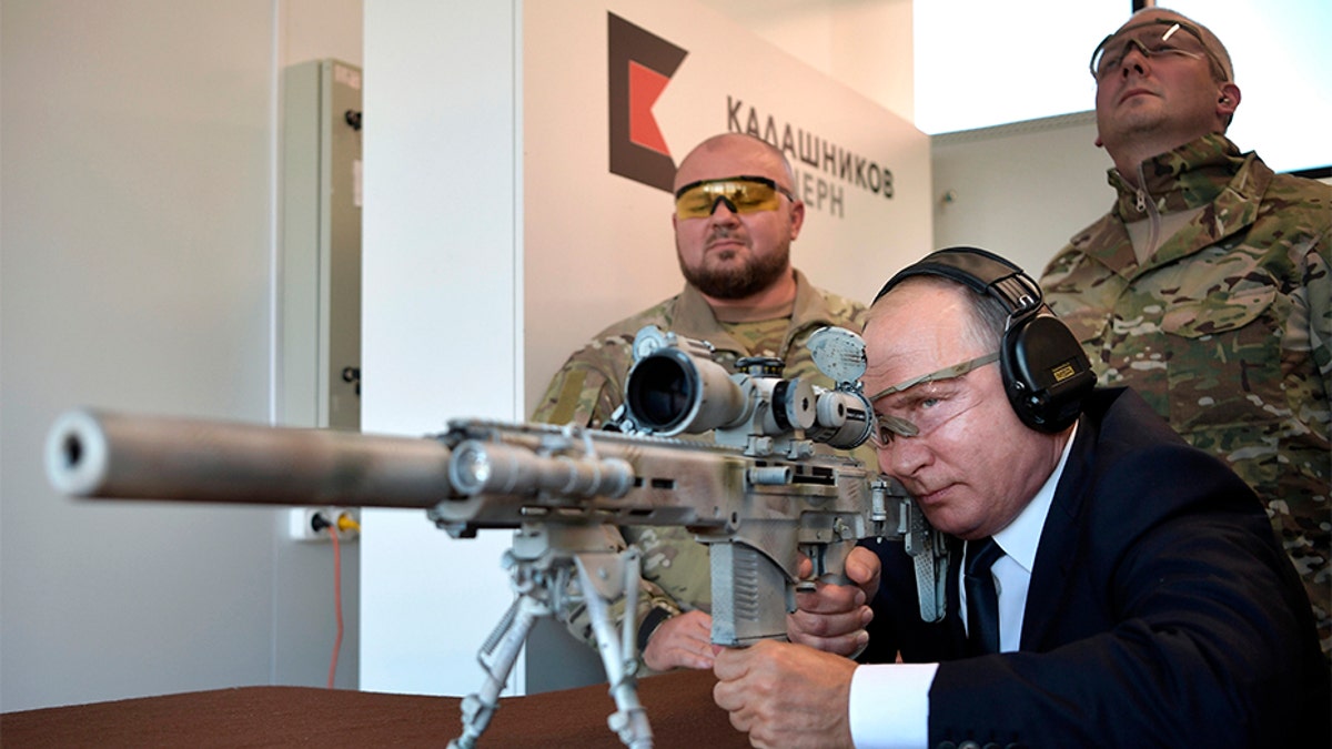 Russian President Vladimir Putin aims a sniper rifle during a visit to the Patriot military exhibition center outside Moscow, Russia, Wednesday, Sept. 19, 2018. Putin chaired a meeting that focused on new arms programs. (Alexei Nikolsky, Sputnik, Kremlin Pool Photo via AP)