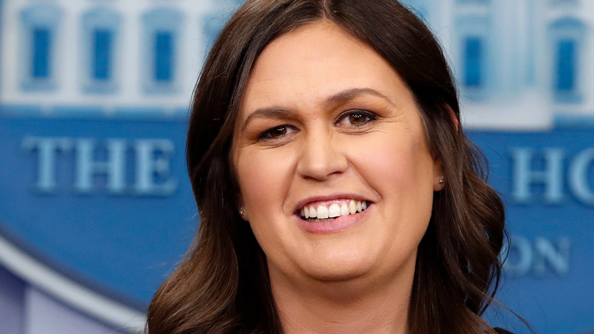 FILE - In this June 14, 2018 file photo, White House Press Secretary Sarah Huckabee Sanders smiles as she wishes President Donald Trump a happy birthday, during the daily briefing,  in the Briefing Room of the White House in Washington. Sanders acknowledges in a tweet that she was asked to leave a Virginia restaurant Friday night, June 22. Sanders said she was told by the owner of The Red Hen in Lexington, Virginia, that she had to 