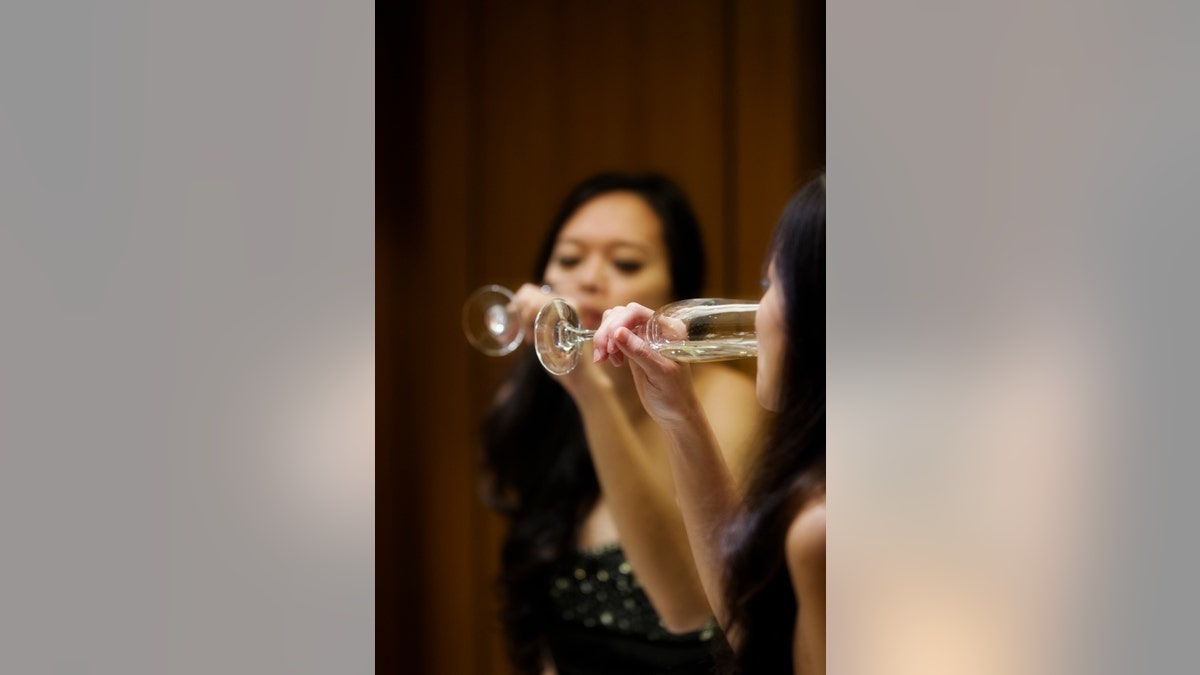 Asian woman drinking champagne