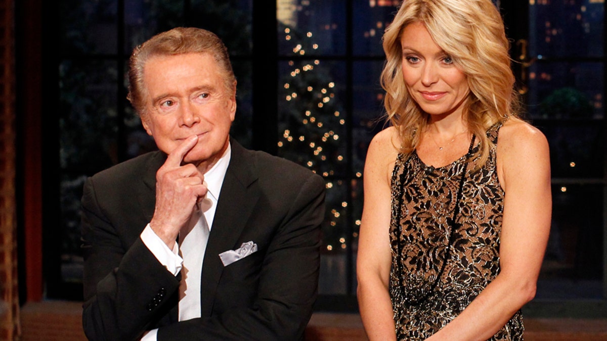Television host Regis Philbin says goodbye with co-host Kelly Ripa (R) during his final show of on  
