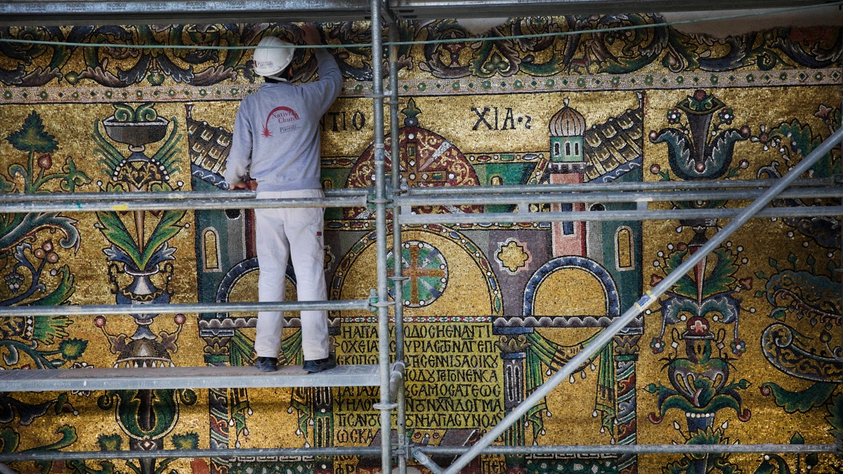 In this Feb. 4, 2016 photo, a restoration expert works on mosaic inside the Church of the Nativity, in the West Bank city of Bethlehem. After two years of painstaking work, experts have completed the initial phase of a delicate restoration project at the Church of the Nativity, giving a much-needed face lift to one of Christianitys holiest sites. (AP Photo/Nasser Nasser)