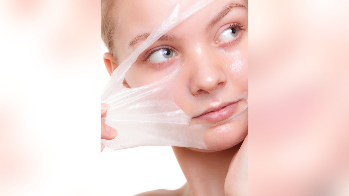 Girl woman in facial peel off mask. Skin care.