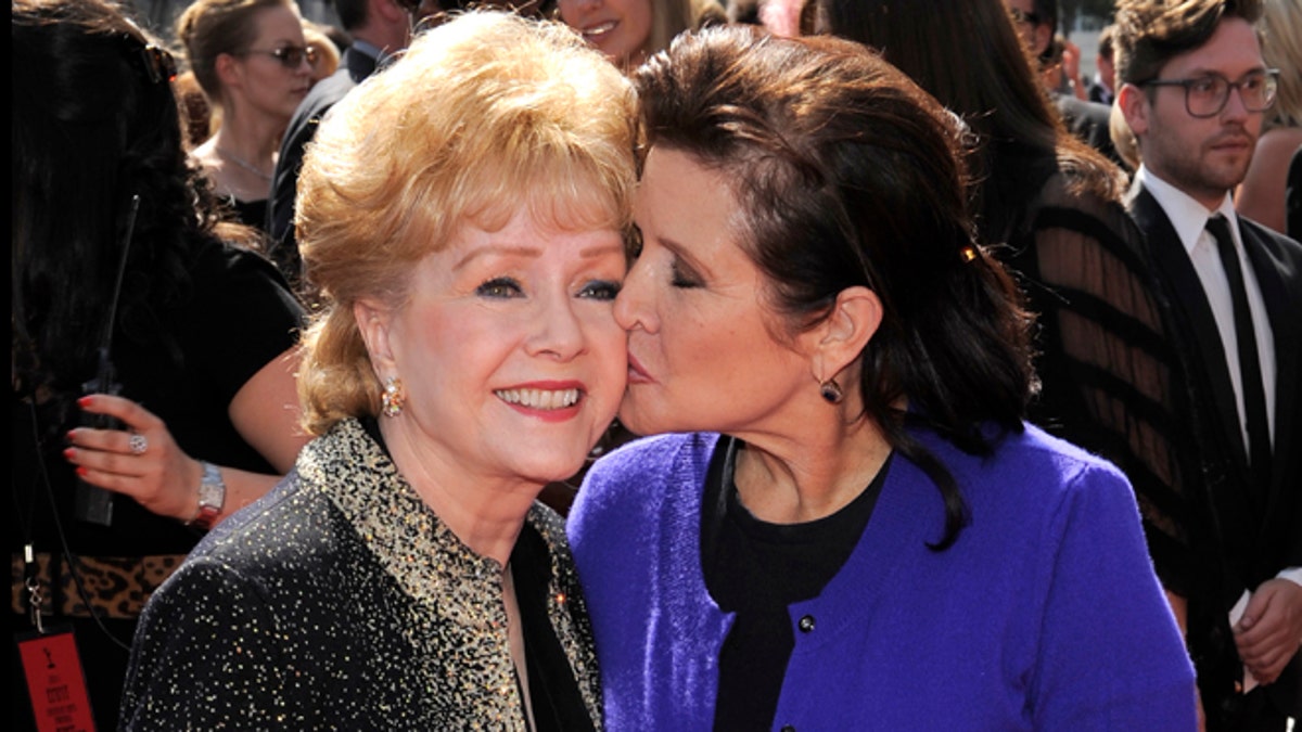 FILE- In this Sept. 10, 2011, file photo, Debbie Reynolds, left, and Carrie Fisher arrive at the Primetime Creative Arts Emmy Awards in Los Angeles. Reynolds, star of the 1952 classic 