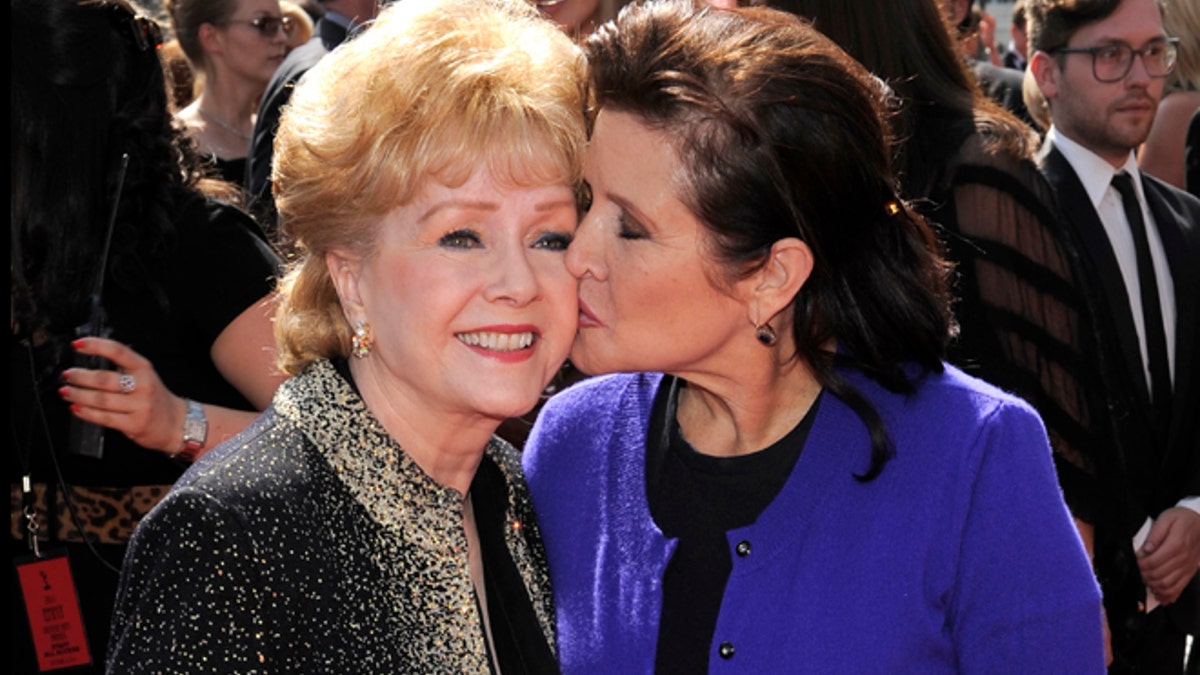 FILE- In this Sept. 10, 2011, file photo, Debbie Reynolds, left, and Carrie Fisher arrive at the Primetime Creative Arts Emmy Awards in Los Angeles. Reynolds, star of the 1952 classic 