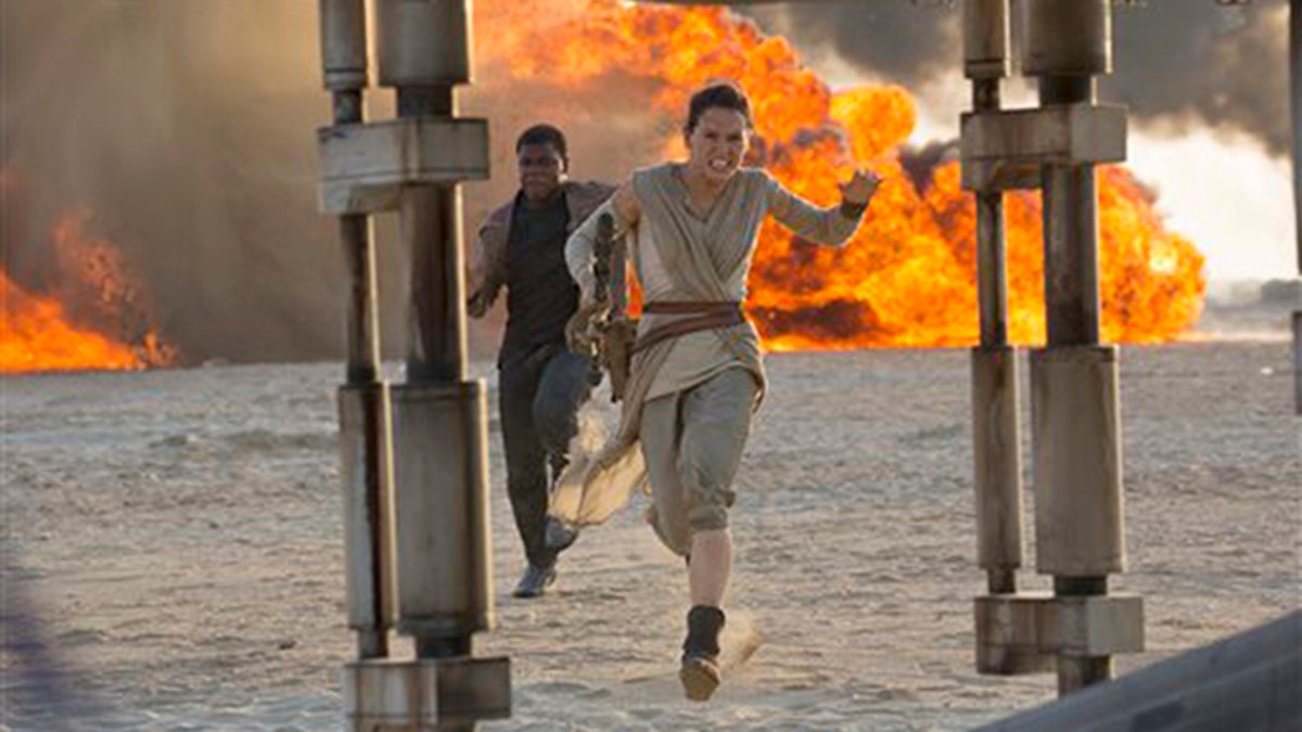 This photo provided by Disney/Lucasfilm shows Daisy Ridley, right, as Rey, and John Boyega as Finn, in a scene from the film, 