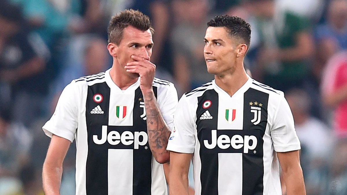 Juventus' Mario Mandzukic, left, talks with his teammate Cristiano Ronaldo during the Serie A soccer match between Napoli and Juventus at the Allianz Stadium in Turin, Italy, Saturday, Sept. 29, 2018. (Alessandro Di Marco/ANSA via AP)