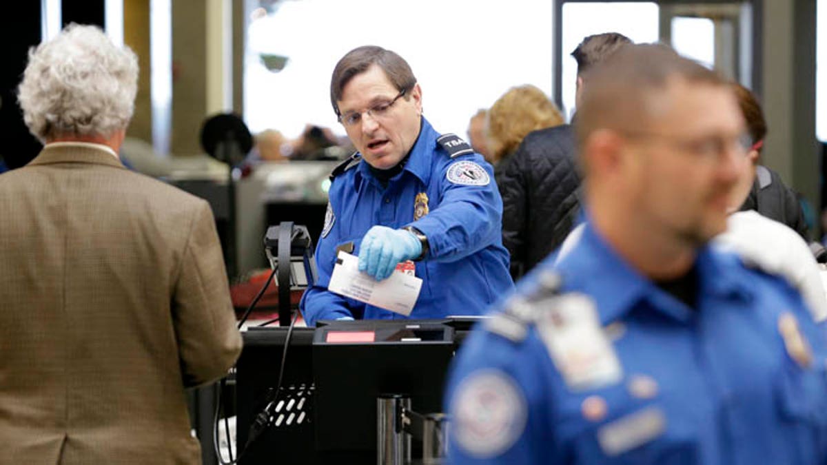 Un agente de la TSA comprueba el billete de un pasajero.