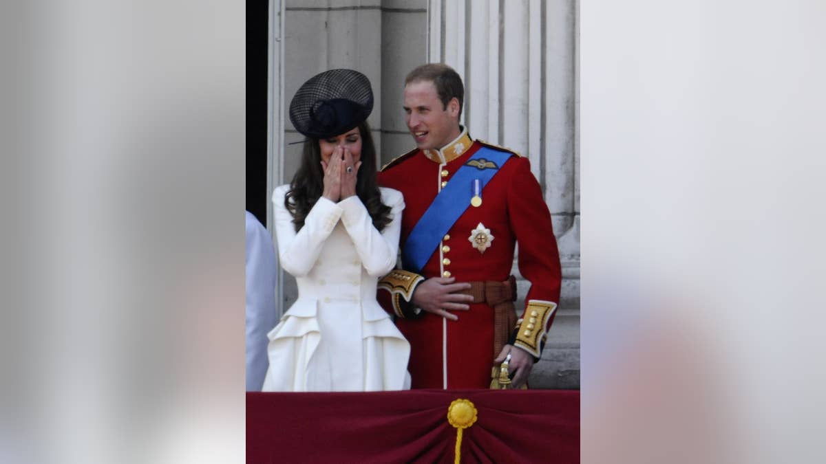 A young Kate Middleton and Prince William on the palace balcony.