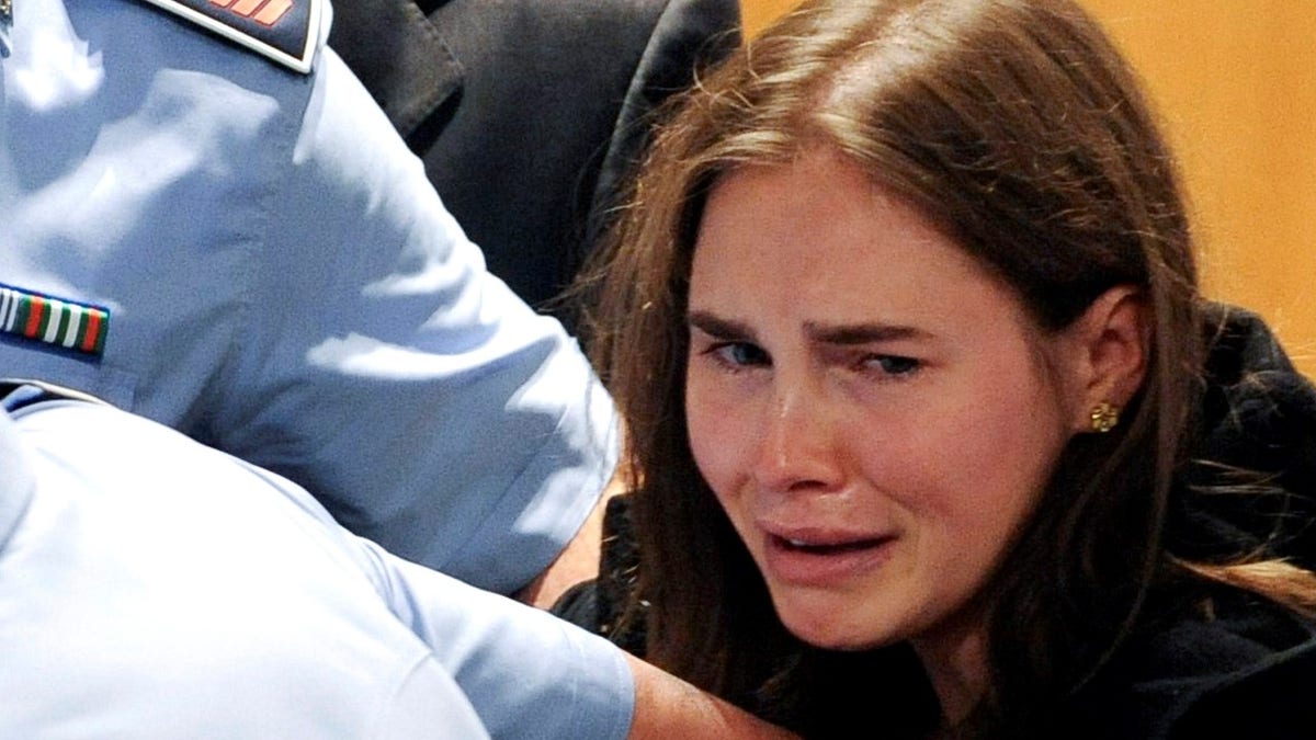 Amanda Knox of the U.S. reacts after the verdict on Knox and Raffaele Sollecito of Italy in the killing of British student Meredith Kercher was announced at a court in Perugia October 3, 2011. The Italian court cleared Knox, a 24-year-old Seattle native, and Sollecito, Knox's former boyfriend, of the 2007 killing of Kercher and ordered they be freed on Monday after nearly four years in prison for a crime they always denied committing. The verdict came after independent forensic investigators sharply criticised police scientific evidence in the original investigation, saying it was unreliable. REUTERS/Tiziana Fabi/Pool (ITALY - Tags: CRIME LAW TPX IMAGES OF THE DAY) - GM1E7A40M6301