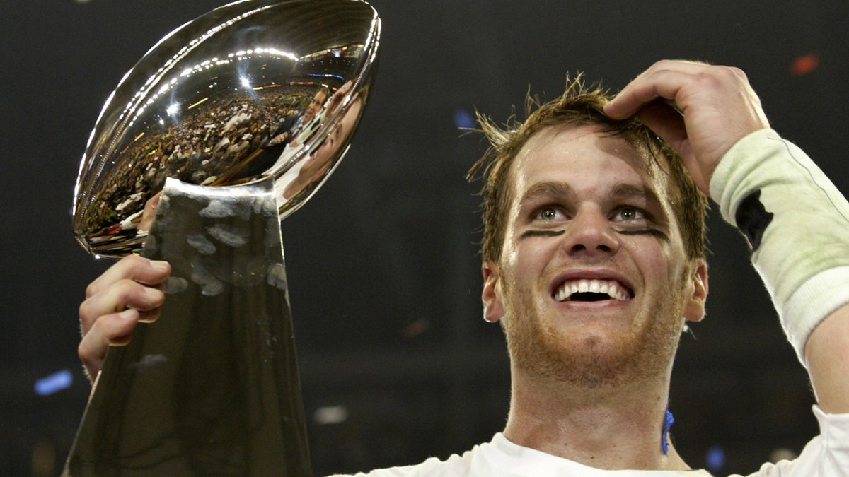 New England Patriots quarterback Tom Brady holds the Vince Lombardi Trophy after winning Super Bowl XXXVIII in Houston, February 1, 2004.