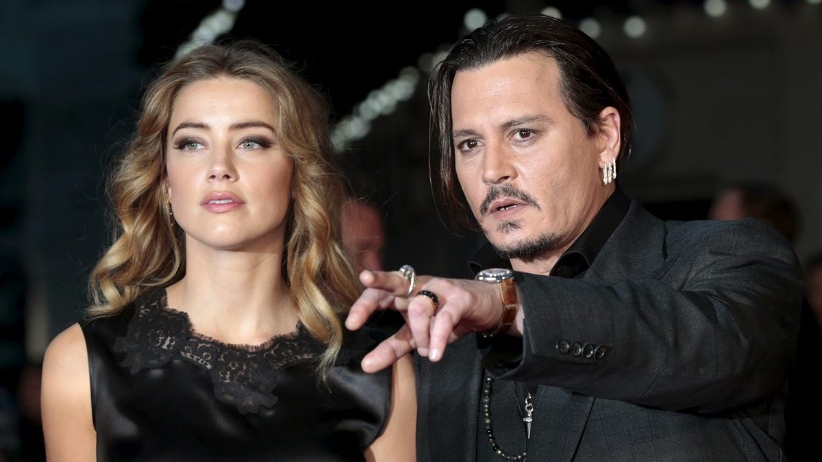 Cast member Johnny Depp and his actress wife Amber Heard arrive for the premiere of the British film 