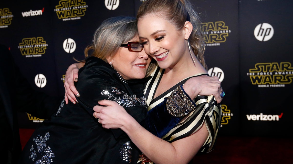 Actresses Carrie Fisher (L) and Billie Lourd embrace as they arrive at the premiere of