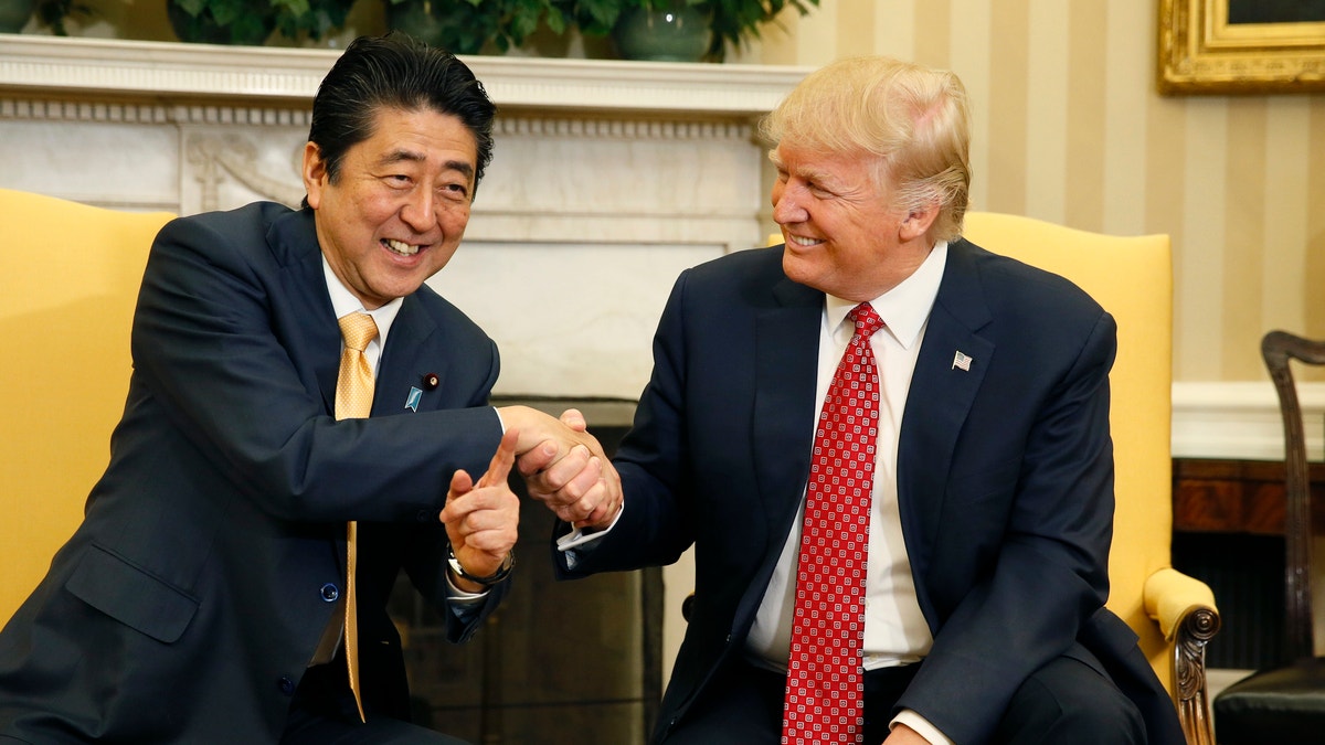 Japanese Prime Minister Shinzo Abe shakes hands with President Trump