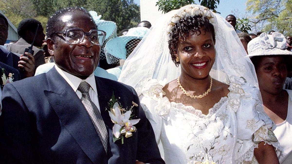 President Robert Mugabe and new wife Grace leave the Kutama Catholic Church August 17, 1996 after exchaning their wedding vows. The couple were traditionally married shortly after the death of Mugabe's first wife Sally. The ceremony was attended by six thousand invited guests.  REUTERS/Howard Burditt - PBEAHUMWKBR