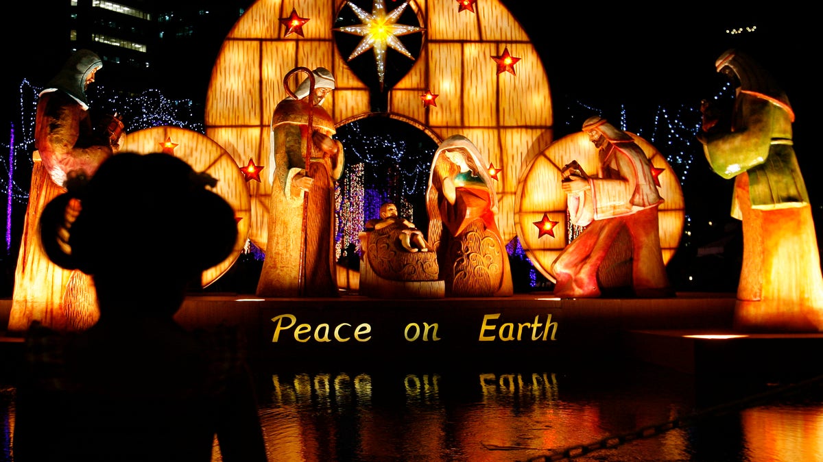 A girl is silhouetted as she views a nativity scene known locally as "Belen" displayed outside the Philippine Stock Exchange in Manila's Makati financial district December 21, 2010. REUTERS/Cheryl Ravelo (PHILIPPINES - Tags: SOCIETY RELIGION) - RTXVXLJ