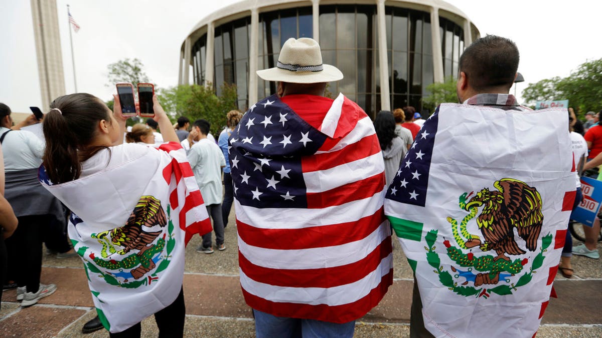 FILE - In this June 26, 2017, file photo, protesters outside the federal courthouse in San Antonio, Texas, take part in a rally to oppose a new Texas 