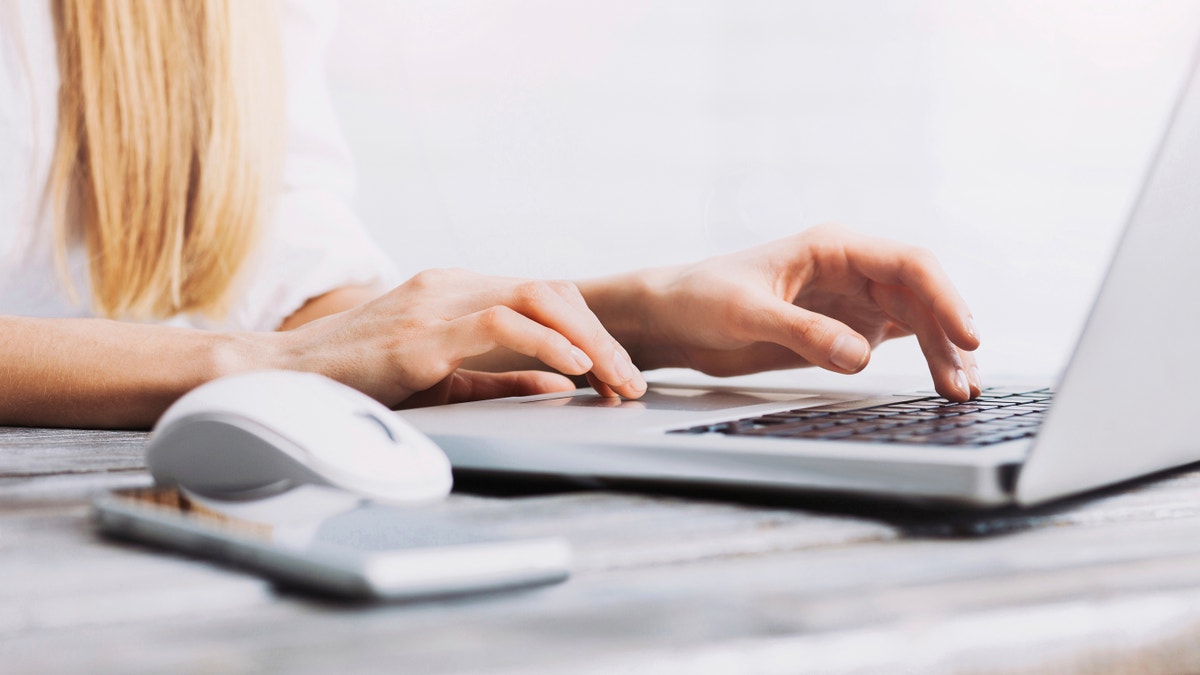 Close-up of female hands on laptop keyboard