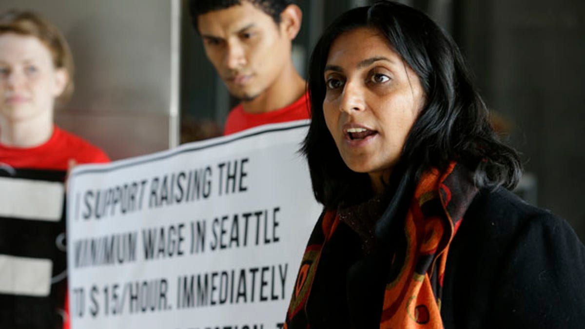 Nov. 4, 2013, Socialist candidate for Seattle City Council Kshama Sawant, right, speaks outside City Council chambers in Seattle about her support for raising the minimum wage to $15 an hour for all workers in the city. 