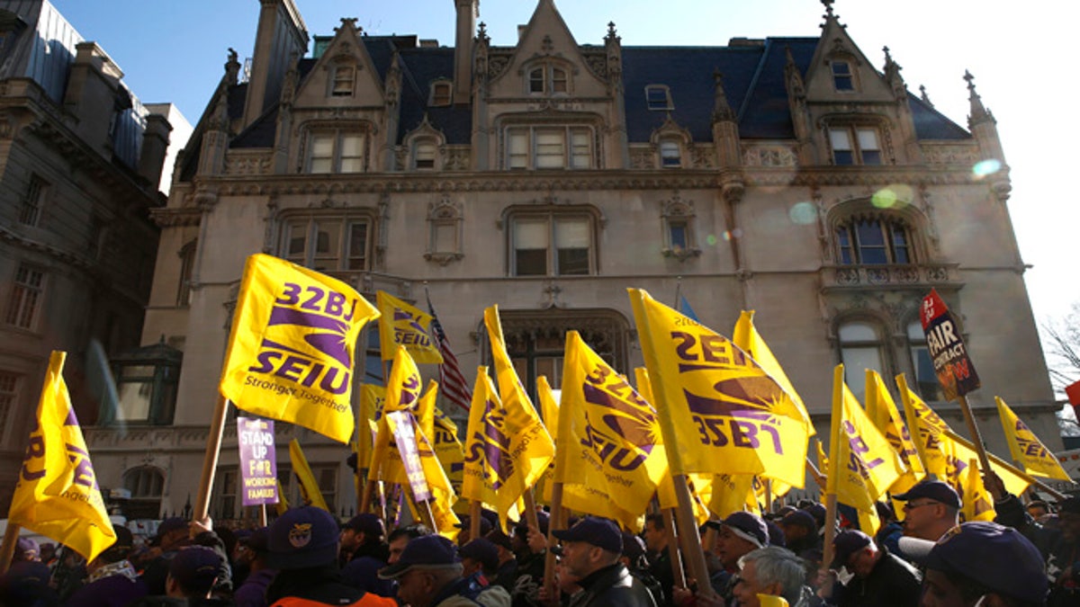 Members of the Service Employees International Union (SEIU) march during a protest in support of a new contract for apartment building workers in New York City, April 2, 2014. Thousands of New York City doormen and other workers marched along one of Manhattan's wealthiest strips of luxury buildings on the Upper East Side to rally for higher wages on Wednesday, ahead of a union vote to authorize a strike if their demands are not met. The contract for more than 30,000 New York City apartment building workers expires on April 20. REUTERS/Mike Segar    (UNITED STATES - Tags: BUSINESS EMPLOYMENT SOCIETY) - RTR3JPJ8