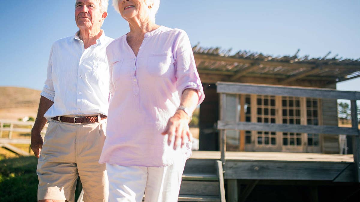 Senior couple holding hands and walking together outdoors