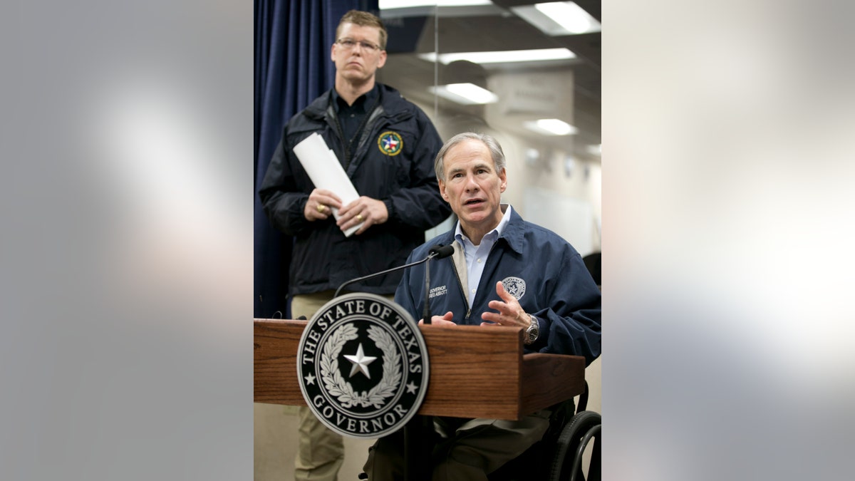 Gov. Greg Abbott talks about the severe weather in Texas at the DPS State Operations Center in Austin, Texas, Sunday, Dec. 27, 2015. Chief Nim Kidd of the Texas Division of Emergency Management, left, listens. Abbott warned that the number of victims from a deadly outbreak of storms and tornadoes in the Dallas area could still rise. Abbott made disaster declarations for four counties, following the severe weather that killed at least 11 people. (Jay Janner/Austin American-Statesman via AP) MANDATORY CREDIT