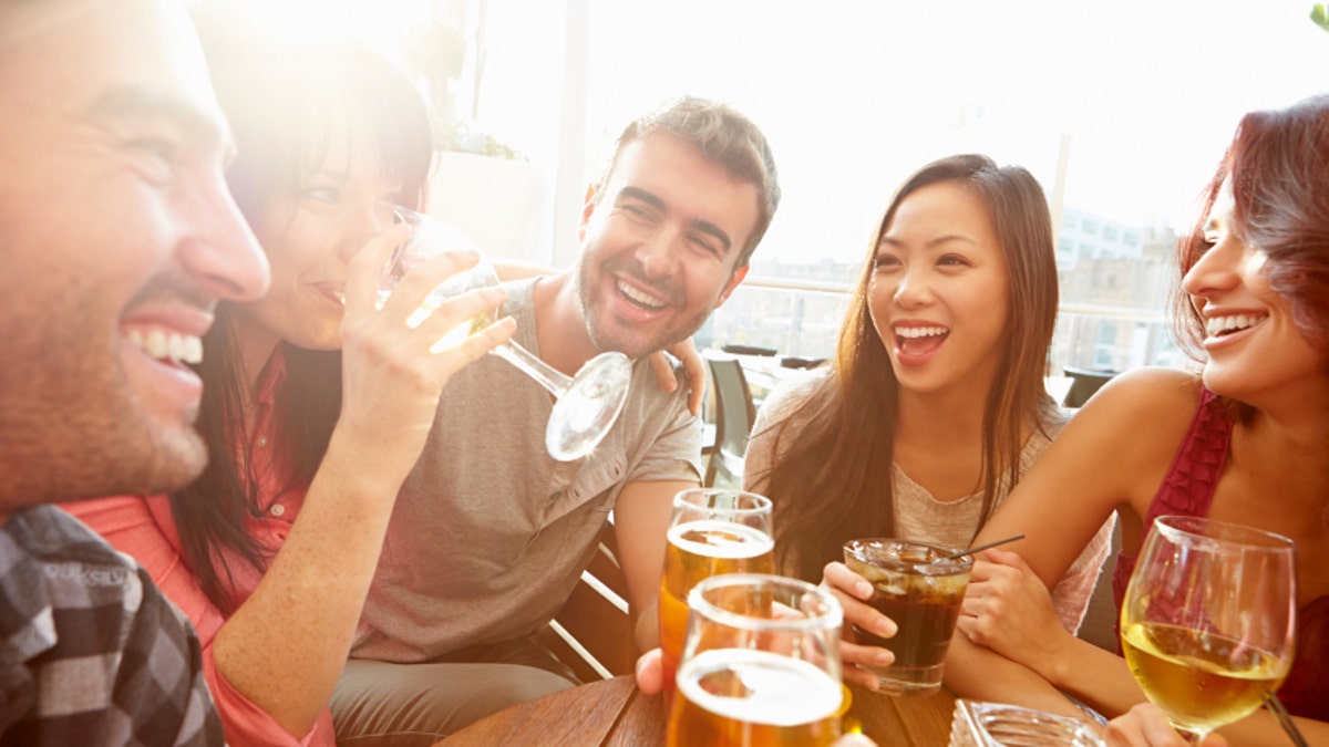 Group Of Friends Enjoying Drink At Outdoor Rooftop Bar