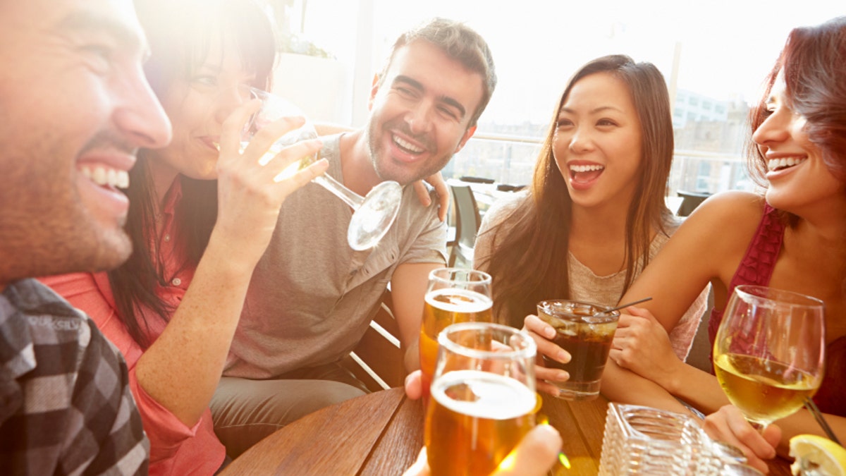 Group Of Friends Enjoying Drink At Outdoor Rooftop Bar