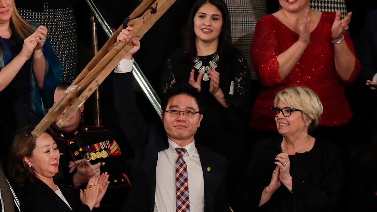 Ji Seong-ho holds up his crutches after his introduction by President Trump during the State of the Union address to a joint session of Congress on Capitol Hill in Washington, Tuesday, Jan. 30, 2018. (AP Photo/J. Scott Applewhite)
