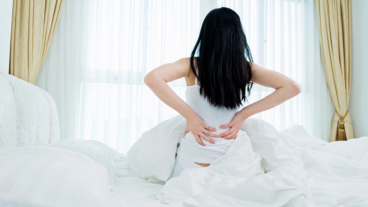 sleeping woman back pain istock