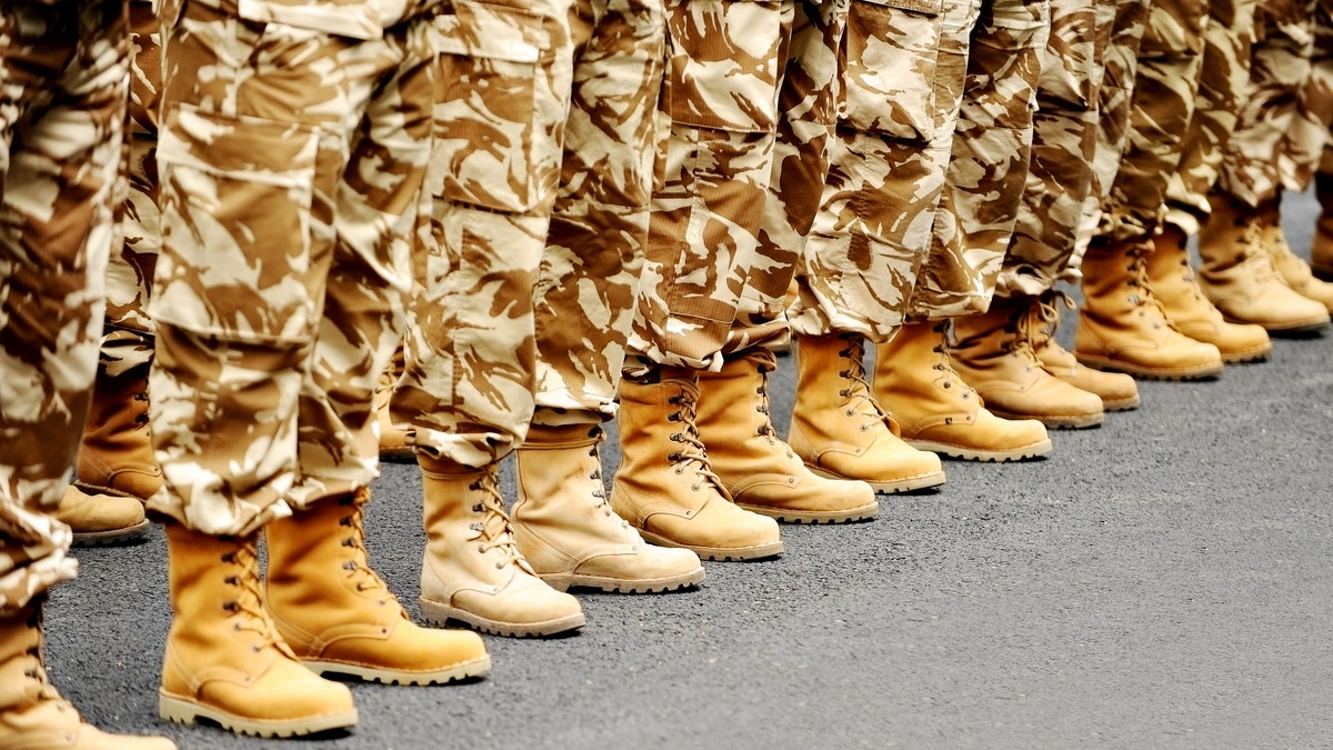 Soldiers feet in desert camouflage military uniform in rest position