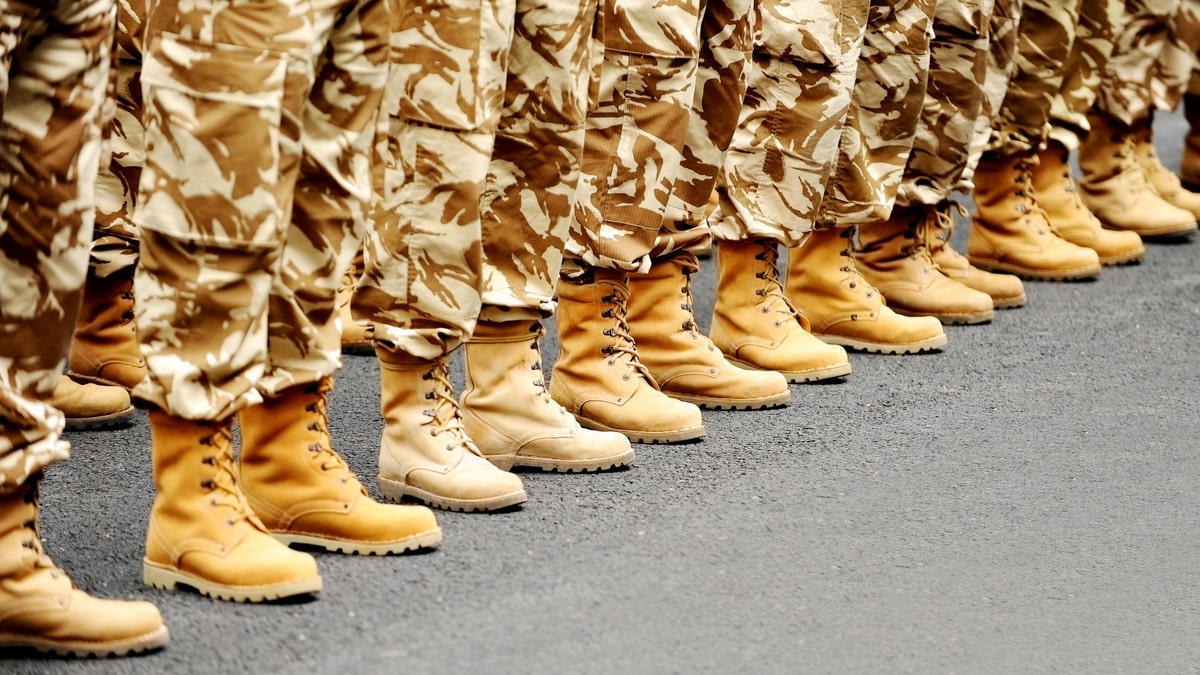 Soldiers feet in desert camouflage military uniform in rest position