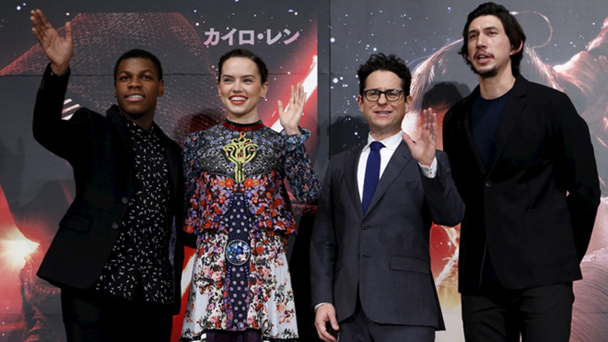 December 11, 2015. Director J.J. Abrams (2nd R), cast members John Boyega (L), Daisy Ridley (2nd L), and Adam Driver pose for pictures with 