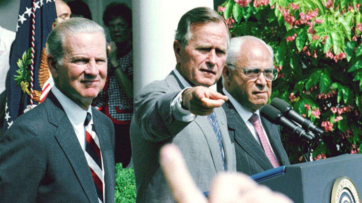 Aug. 20, 1991: President George H.W. Bush, flanked by  Secretary of State James Baker III, left, and U. S. Ambassador to the Soviet Union Robert Strauss, points to a reporter during a Rose Garden press conference at the White House.