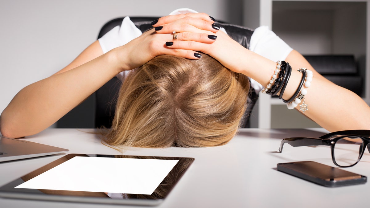 Tired business woman resting her head on desk