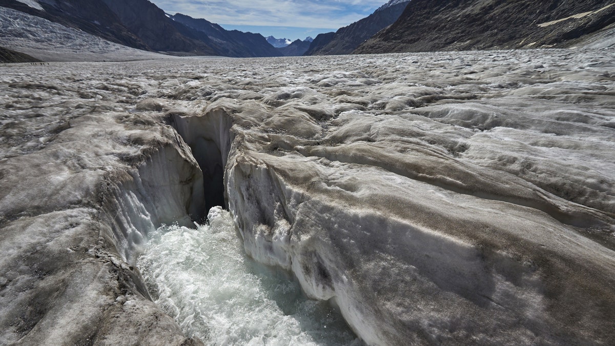 Water from the melting glacier runs down through a hole in the Aletsch Glacier on the Jungfraufirn Glacier, Switzerland, August 28, 2015. One of Europe's biggest glaciers, the Great Aletsch coils 23 km (14 miles) through the Swiss Alps - and yet this mighty river of ice could almost vanish in the lifetimes of people born today because of climate change. The glacier, 900 metres (2,950 feet) thick at one point, has retreated about 3 km (1.9 miles) since 1870 and that pace is quickening.  REUTERS/Denis Balibouse??PICTURE 10 OF 31 FOR WIDER IMAGE STORY 