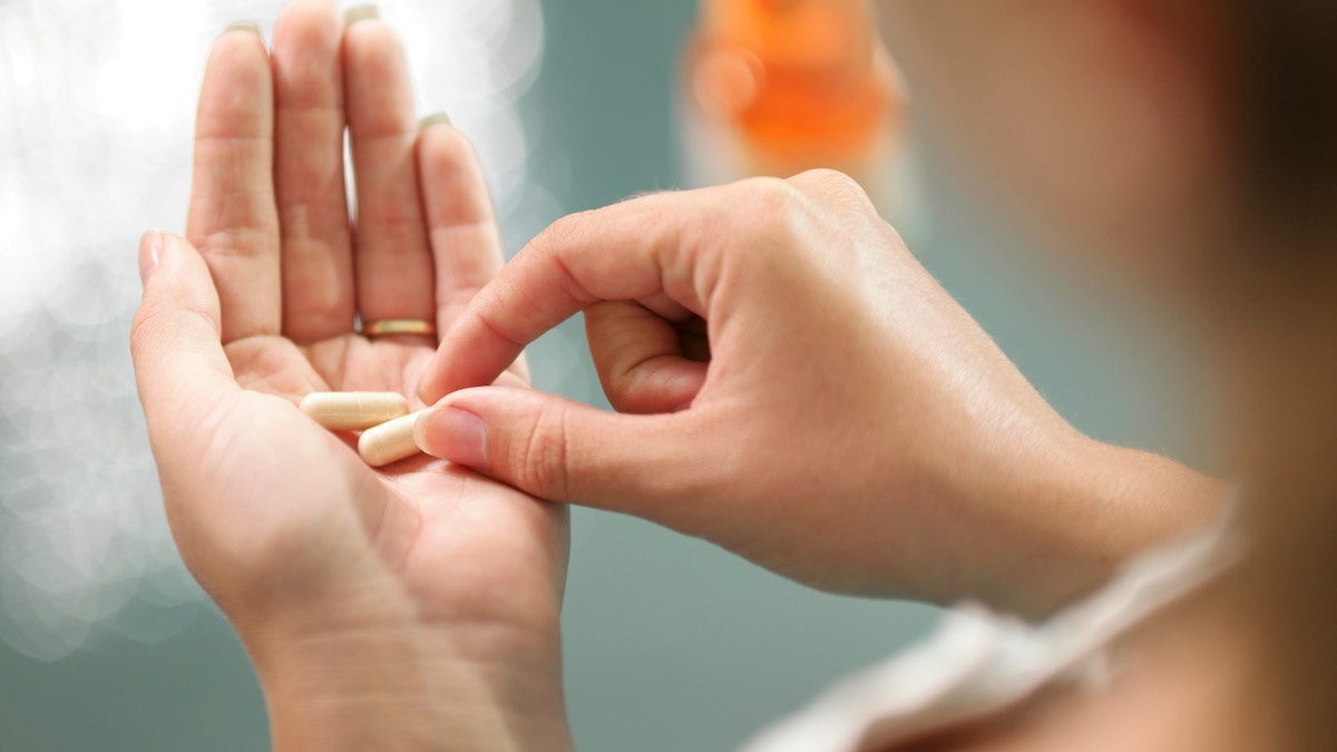 taking an herbal supplement istock large