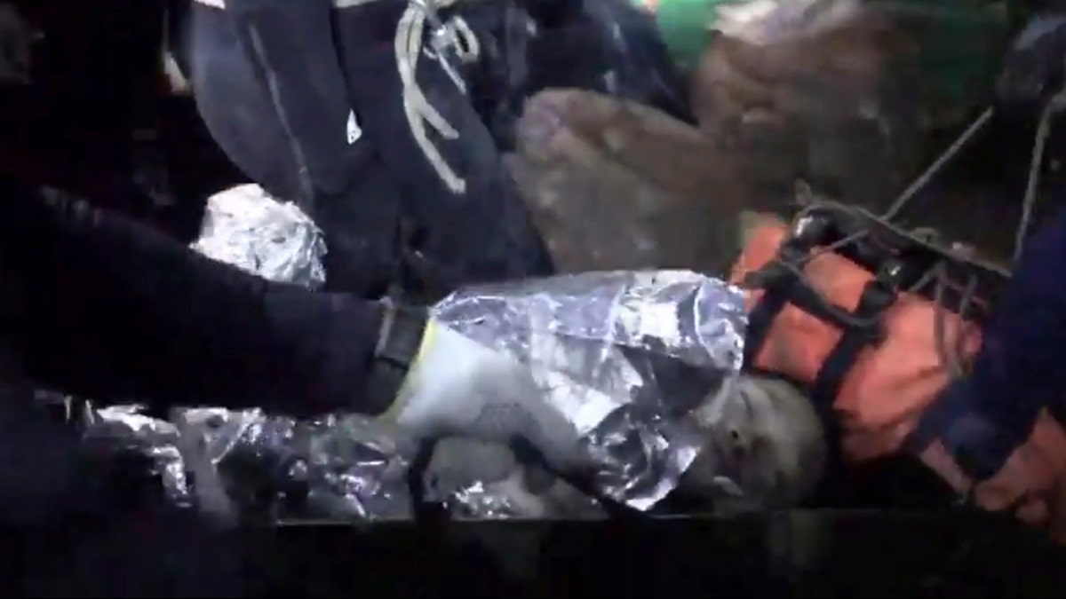 This undated photo from video released via the Thai NavySEAL Facebook Page on Wednesday, July 11, 2018, shows rescuers hold an evacuated boy inside the Tham Luang Nang Non cave in Mae Sai, Chiang Rai province, in northern Thailand. A daring rescue mission in the treacherous confines of a flooded cave in northern Thailand has saved all 12 boys and their soccer coach who were trapped deep within the labyrinth, ending a grueling 18-day ordeal that claimed the life of an experienced volunteer diver and riveted people around the world. (Thai NavySEAL Facebook Page via AP)