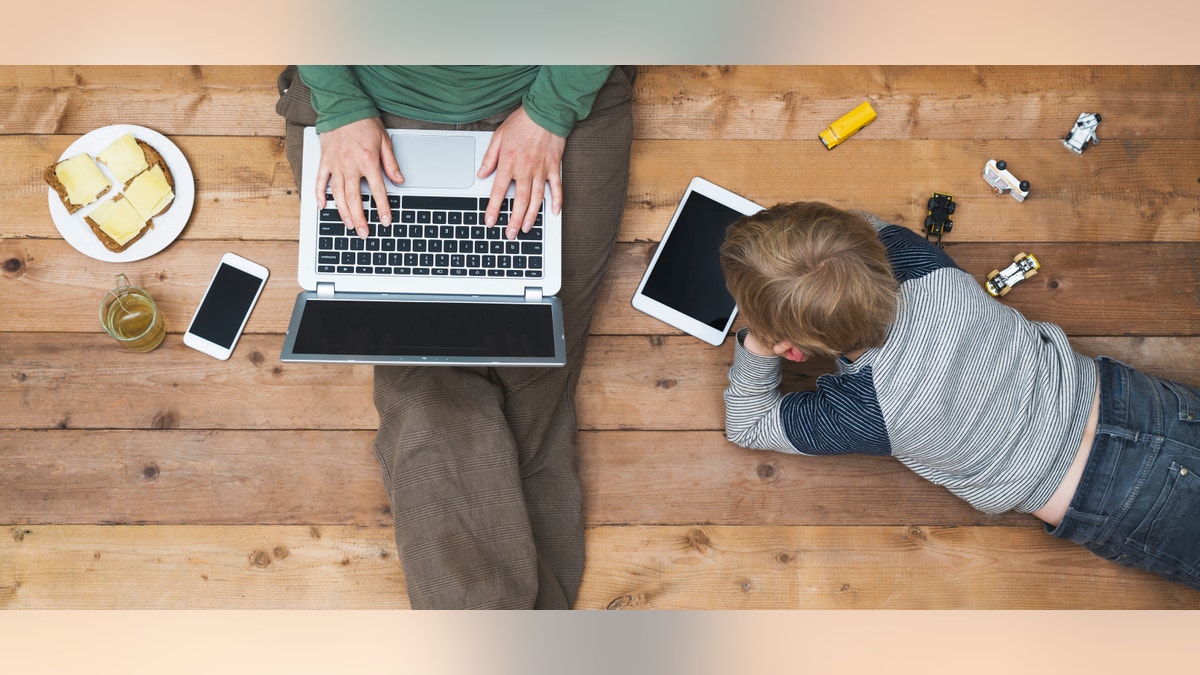 top view of mother and son using digital media. Modern online generation addicted to internet.