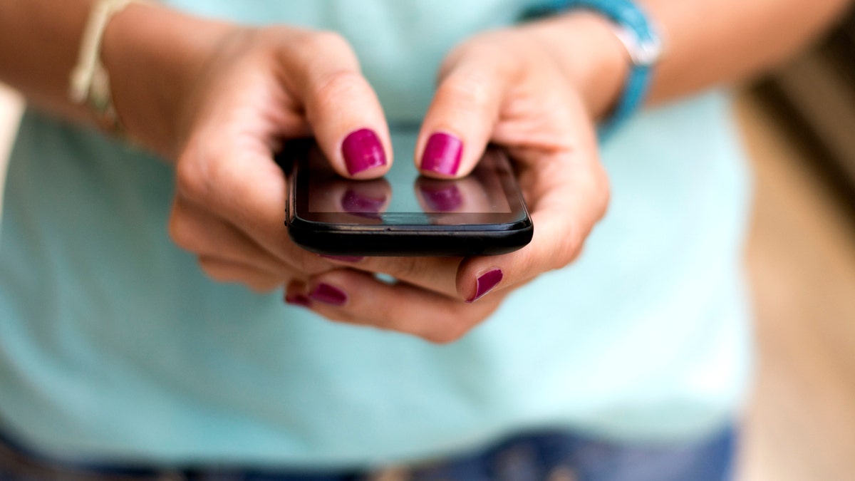 Girl holding smart phone outside