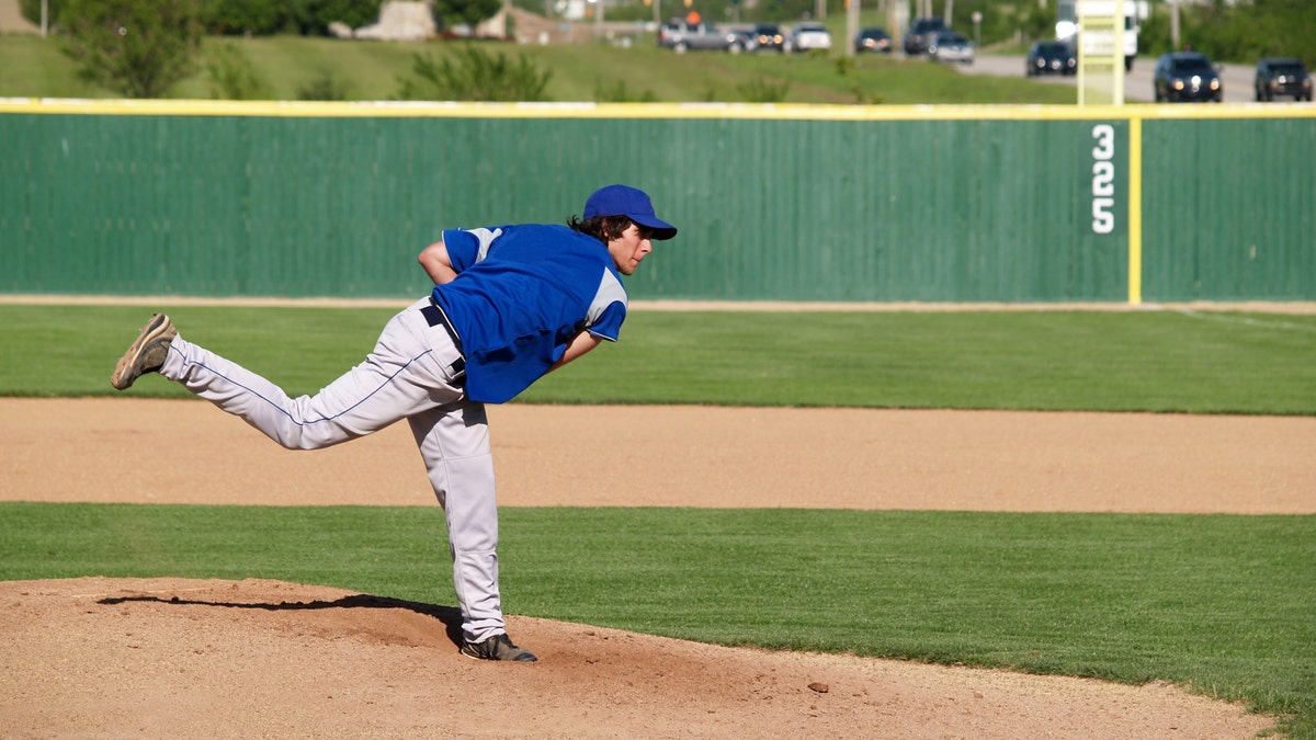 teenager throwing baseball istock