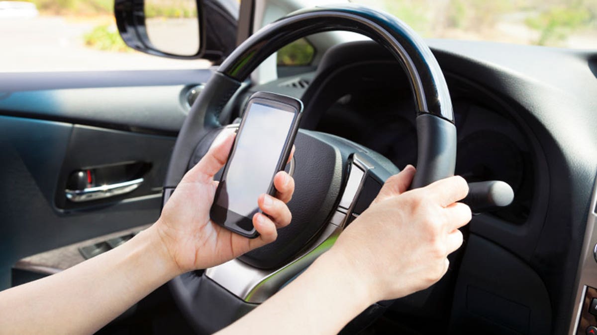 smart phone in hand  while driving the car