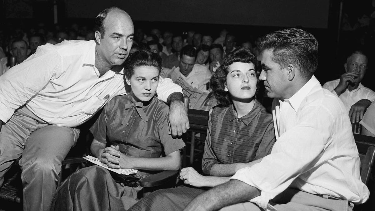 FILE - In this Sept. 23, 1955, file photo, J.W. Milam, left, his wife, second left, Roy Bryant, far right, and his wife, Carolyn Bryant, sit together in a courtroom in Sumner, Miss. Bryant and his half-brother Milam were charged with murder but acquitted in the kidnap-torture slaying of 14-year-old black teen Emmett Till in 1955 after he allegedly whistled at Carolyn Bryant. The men later confessed in a magazine interview but werenÃ¢â¬â¢t retried; both are now dead. Citing "new information," the U.S. Justice Department has reopened the investigation into Till's death. (AP Photo, File)