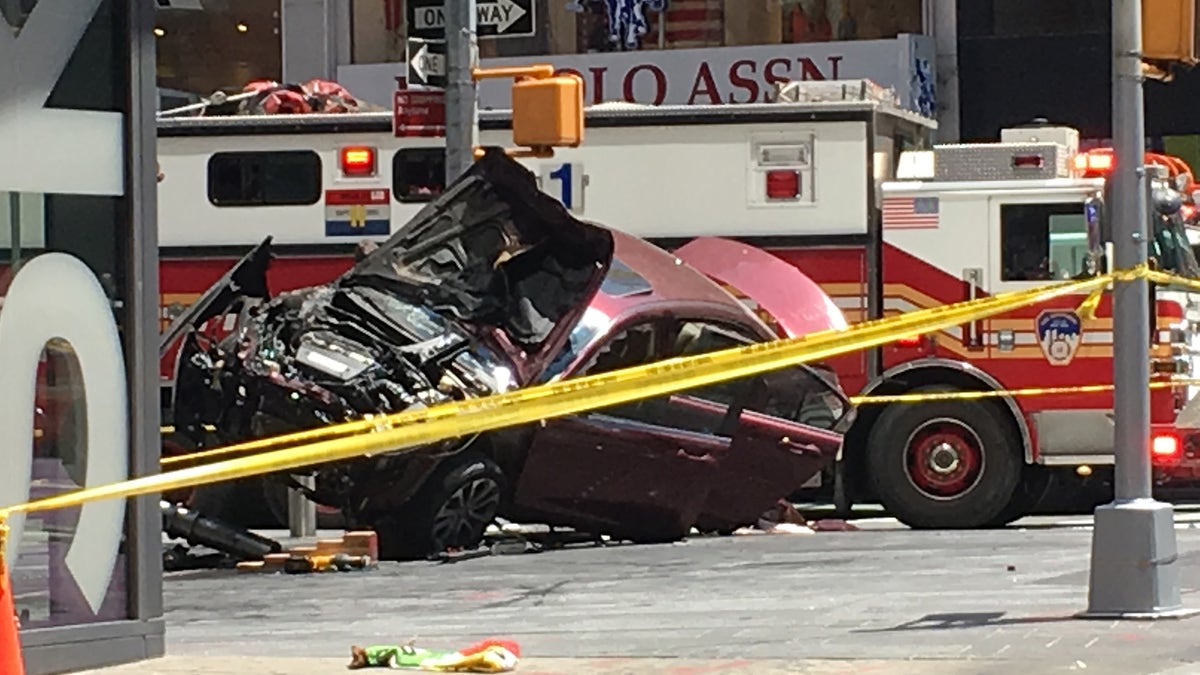 A smashed car sits on the corner of Broadway and 45th Street in New York's Times Square after driving through a crowd of pedestrians