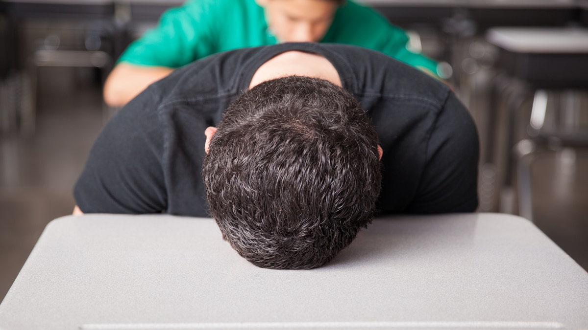 tired teenager falling asleep in class sleep deprived istock large