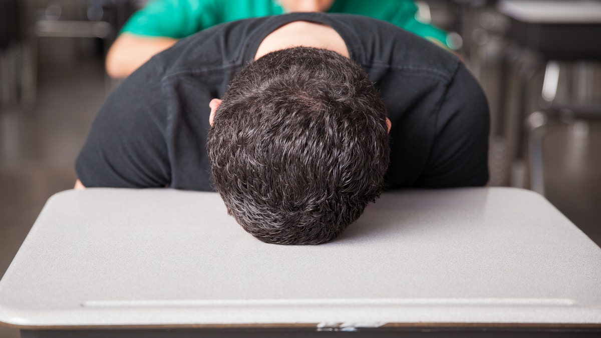 tired teenager falling asleep in class sleep deprived istock large