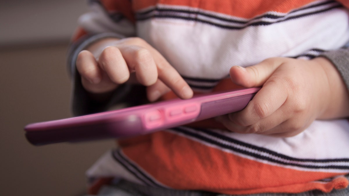 toddler playing with an iphone istock medium