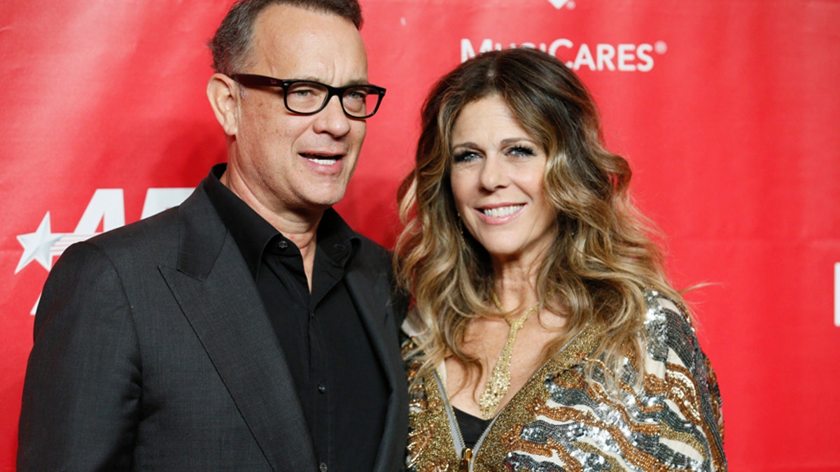 Actor Tom Hanks (L) and Rita Wilson (R) pose at the 2014 MusiCares Person of the Year gala honoring Carole King in Los Angeles, January 24, 2014.