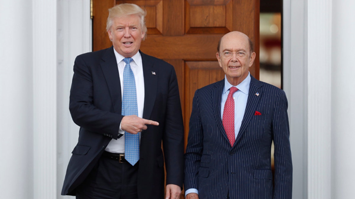 FILE - In this Sunday, Nov. 20, 2016, file photo, President-elect Donald Trump, left, stands with investor Wilbur Ross after meeting at the Trump National Golf Club Bedminster clubhouse in Bedminster, N.J. Trump is poised to offer the position of commerce secretary to the head of a private-equity firm, Wilbur Ross. (AP Photo/Carolyn Kaster)