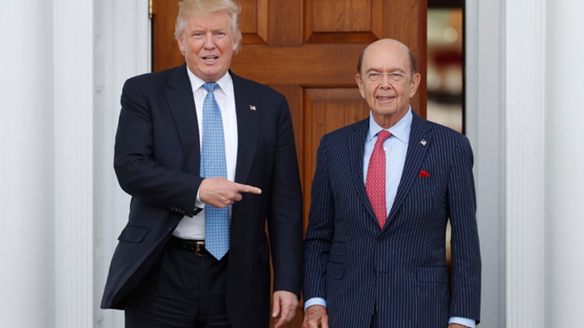 FILE - In this Sunday, Nov. 20, 2016, file photo, President-elect Donald Trump, left, stands with investor Wilbur Ross after meeting at the Trump National Golf Club Bedminster clubhouse in Bedminster, N.J. Trump is poised to offer the position of commerce secretary to the head of a private-equity firm, Wilbur Ross. (AP Photo/Carolyn Kaster)